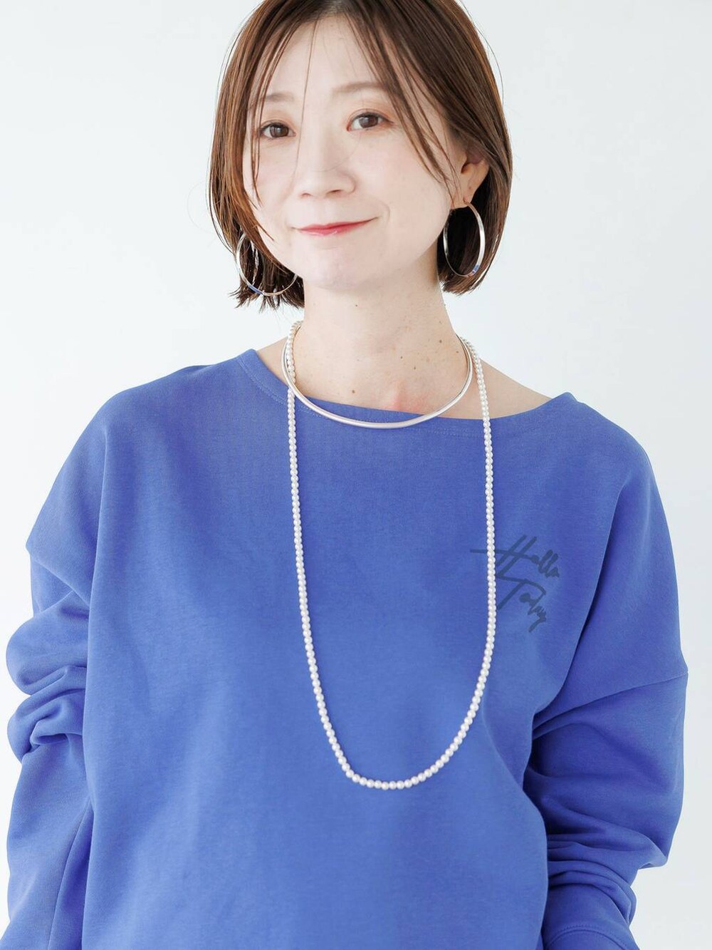 シルバー系のローファー、ブルー系のデニムパンツを着用したレディースの秋コーディネートの8枚目の写真