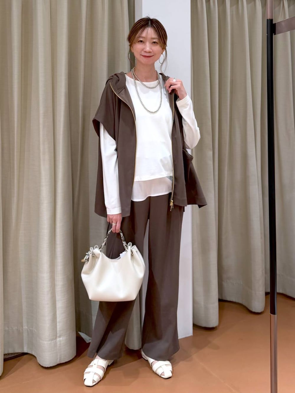 ブラウン系のその他パンツ、ホワイト系のパンプス、ホワイト系のTシャツ/カットソーを着用したレディースの春コーディネートの2枚目の写真
