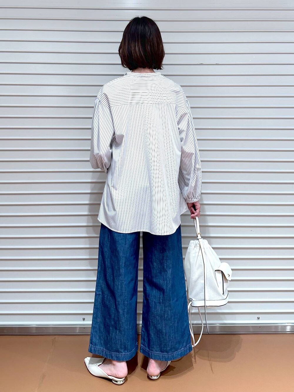 ブルー系のデニムパンツ、ホワイト系のシャツ/ブラウス、ベージュ系のマウンテンパーカーを着用したレディースの春コーディネートの6枚目の写真