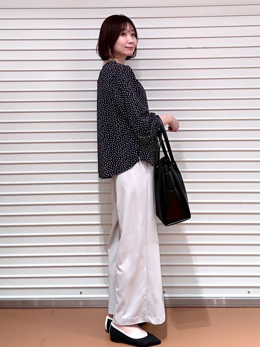ブラック系のパンプス、ブラック系のトートバッグ、ベージュ系のその他パンツを着用したレディースの春コーディネートの3枚目の写真