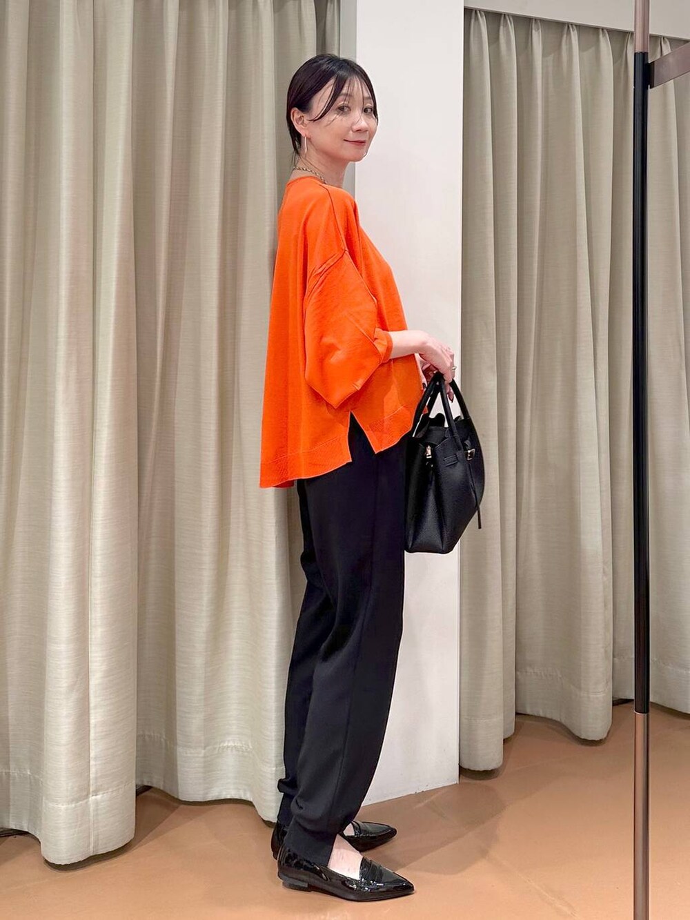 ブラック系のハンドバッグ、ブラック系のパンプス、ブラック系のその他パンツを着用したレディースの春コーディネートの3枚目の写真