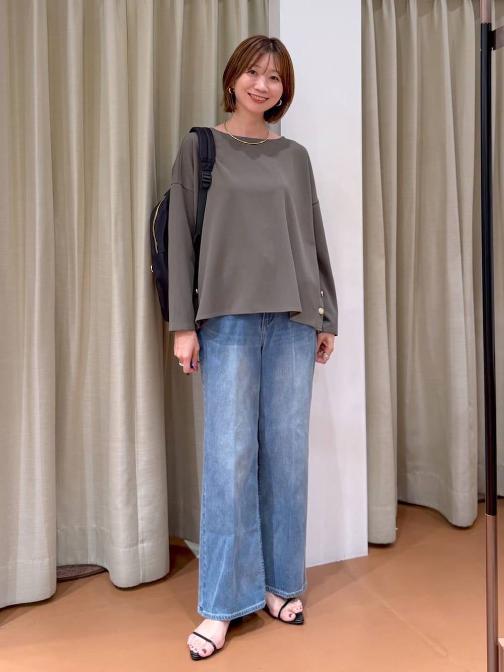 グリーン系のTシャツ/カットソー、ブラック系のバックパック/リュック、ブラック系のサンダルを着用したレディースの秋コーディネートの2枚目の写真