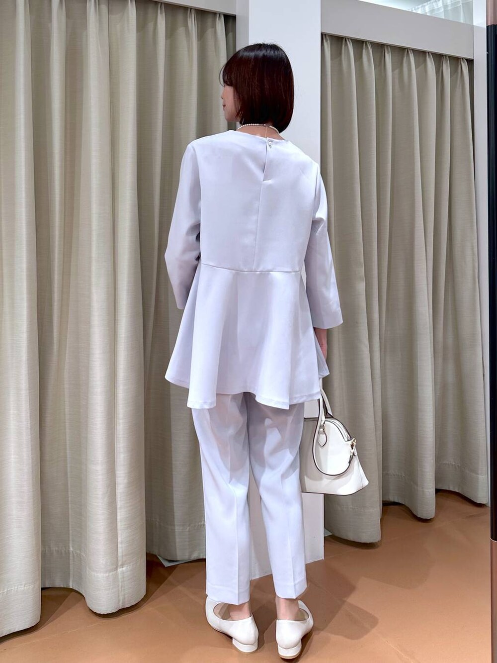 ブルー系のスーツパンツ、ブルー系のシャツ/ブラウス、ホワイト系のハンドバッグを着用したレディースの冬コーディネートの4枚目の写真