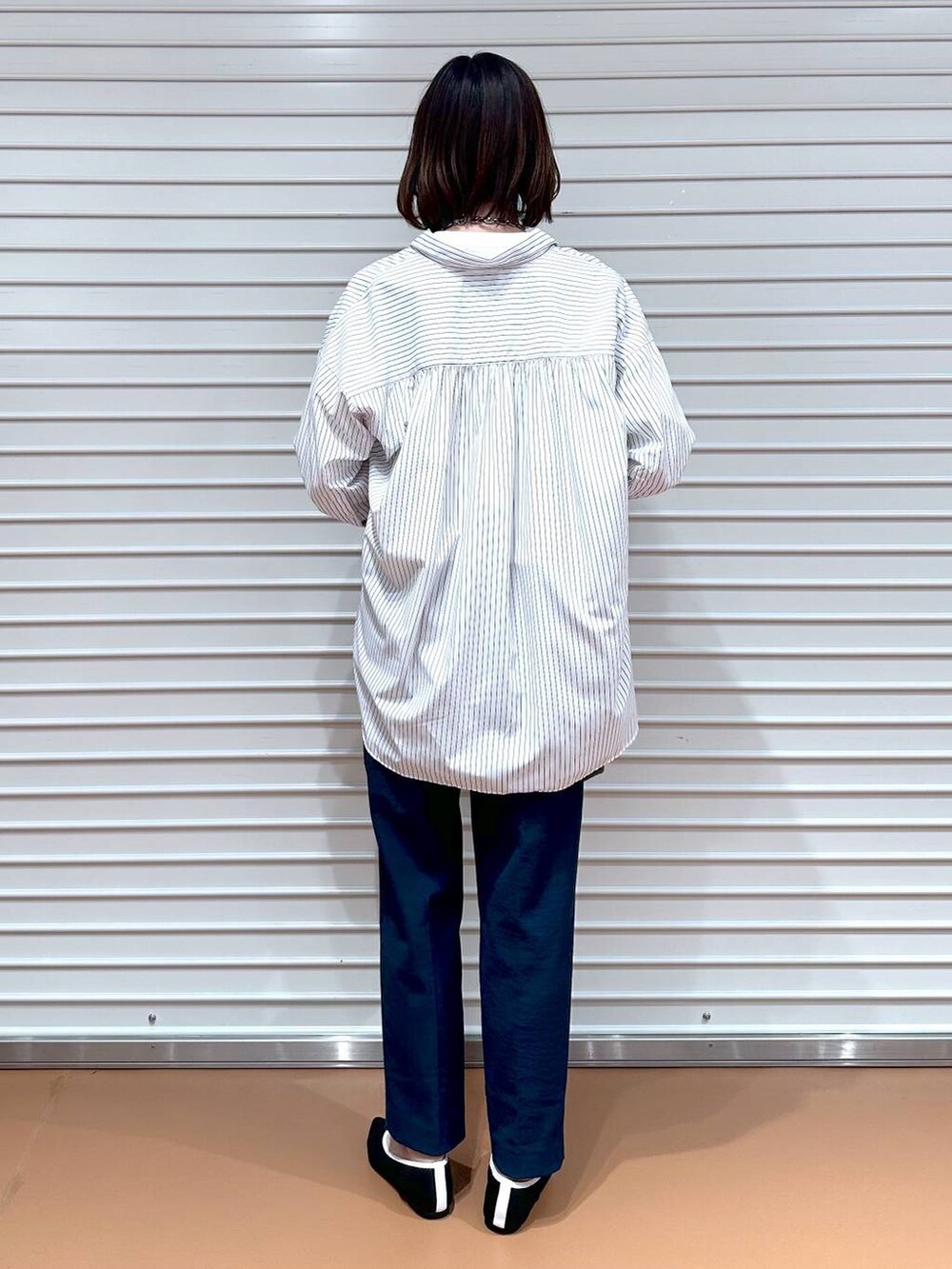 ブラック系のパンプス、ホワイト系のシャツ/ブラウス、ブラック系のバックパック/リュックを着用したレディースの春コーディネートの4枚目の写真