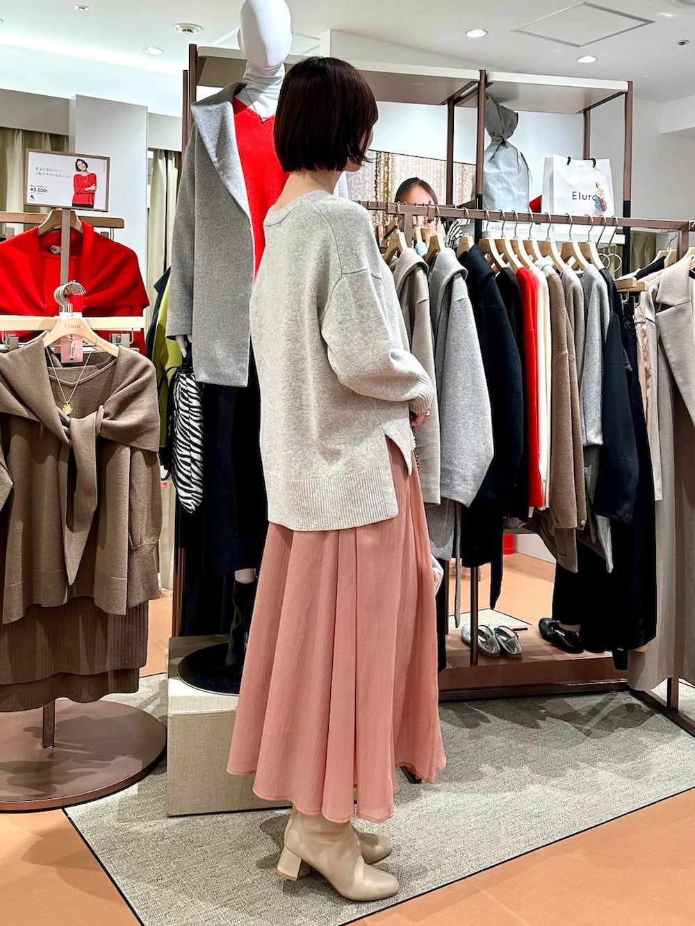 グレー系のニット/セーター、ベージュ系のブーツ、ピンク系のスカートを着用したレディースの冬コーディネートの5枚目の写真