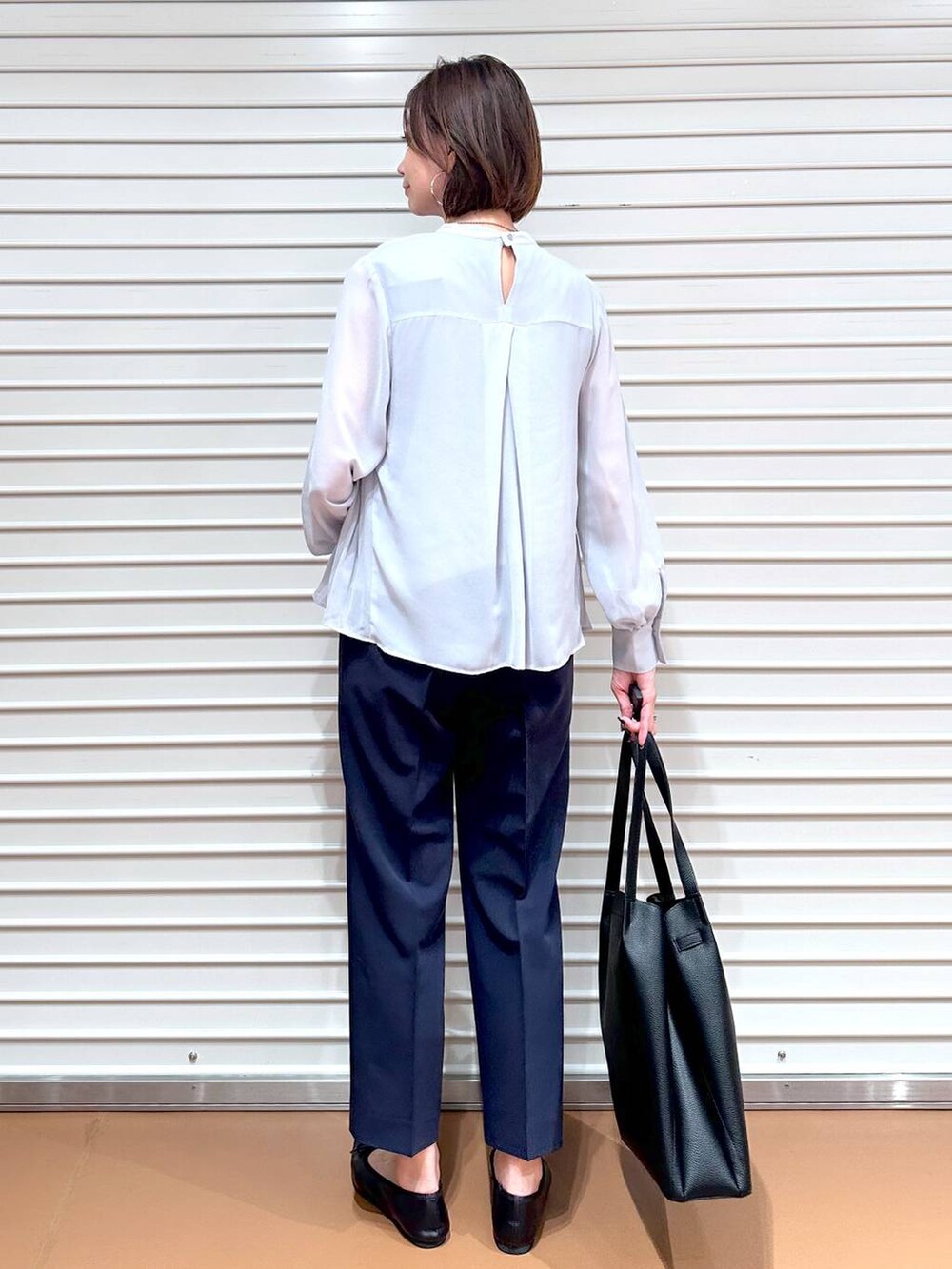 ブルー系のその他パンツ、ブラック系のトートバッグ、ブラック系のパンプスを着用したレディースの秋コーディネートの4枚目の写真