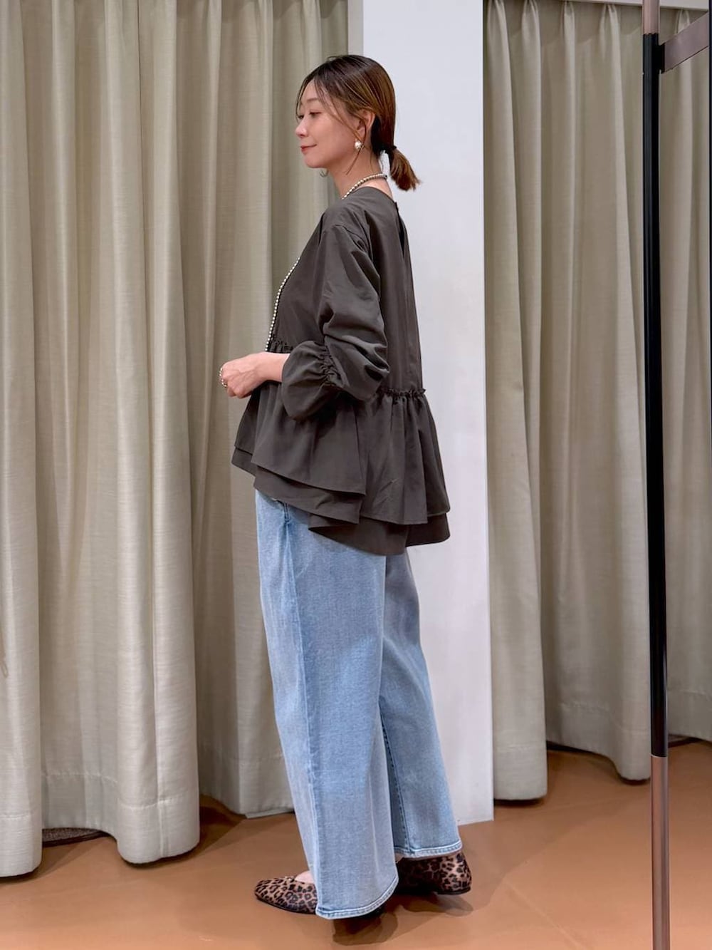 ホワイト系のハンドバッグ、ブルー系のデニムパンツ、ブラウン系のシャツ/ブラウスを着用したレディースの冬コーディネートの3枚目の写真