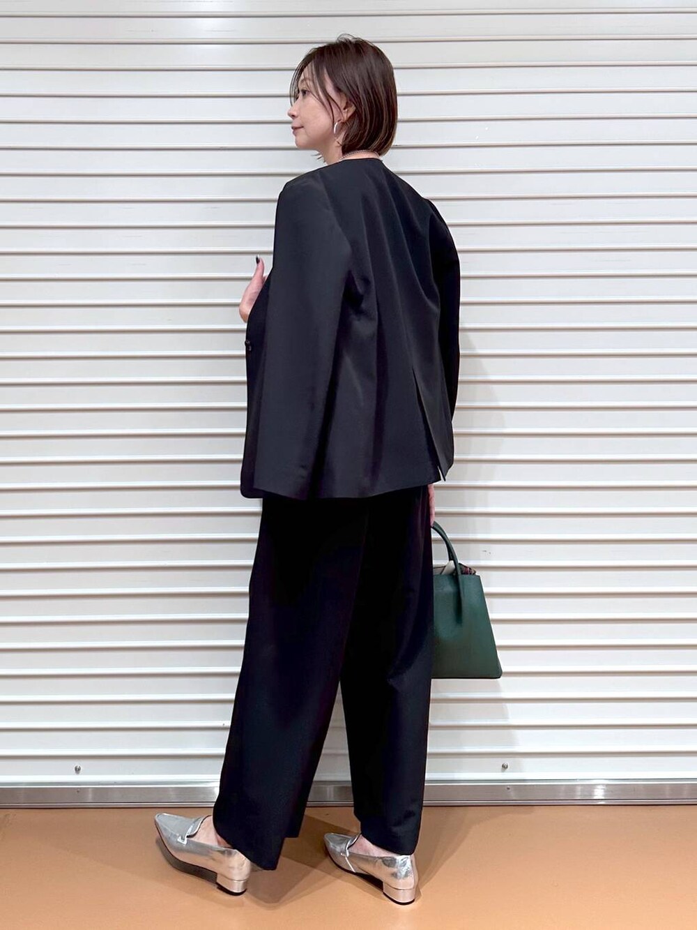 ブラック系のその他アウター、ブラック系のその他パンツ、ホワイト系のTシャツ/カットソーを着用したレディースの秋コーディネートの4枚目の写真