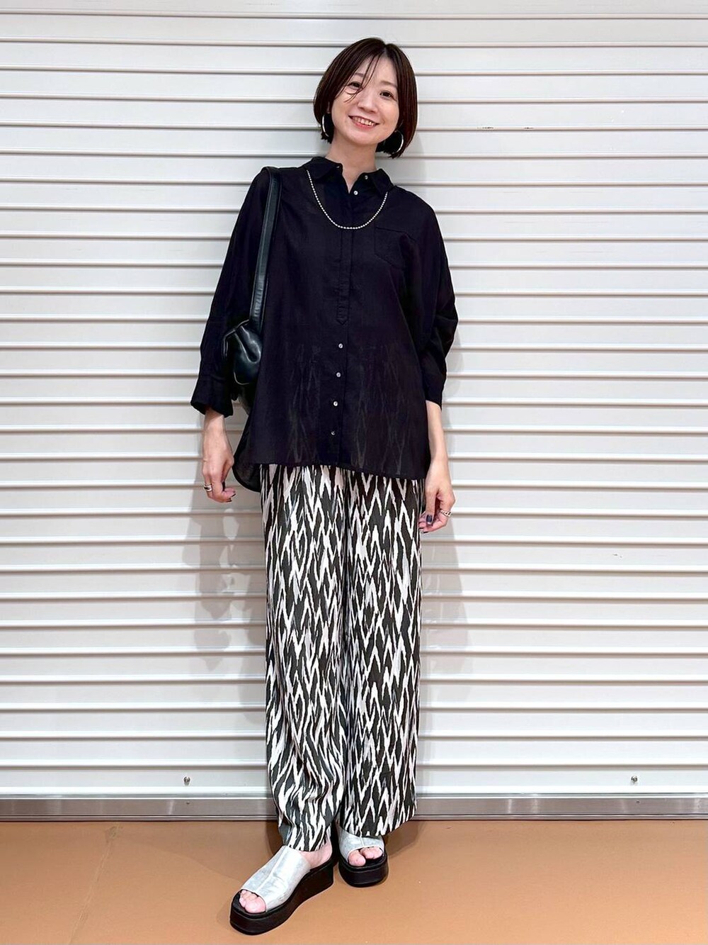 ブラック系のシャツ/ブラウス、シルバー系のサンダル、ブラック系のその他パンツを着用したレディースの夏コーディネートの2枚目の写真