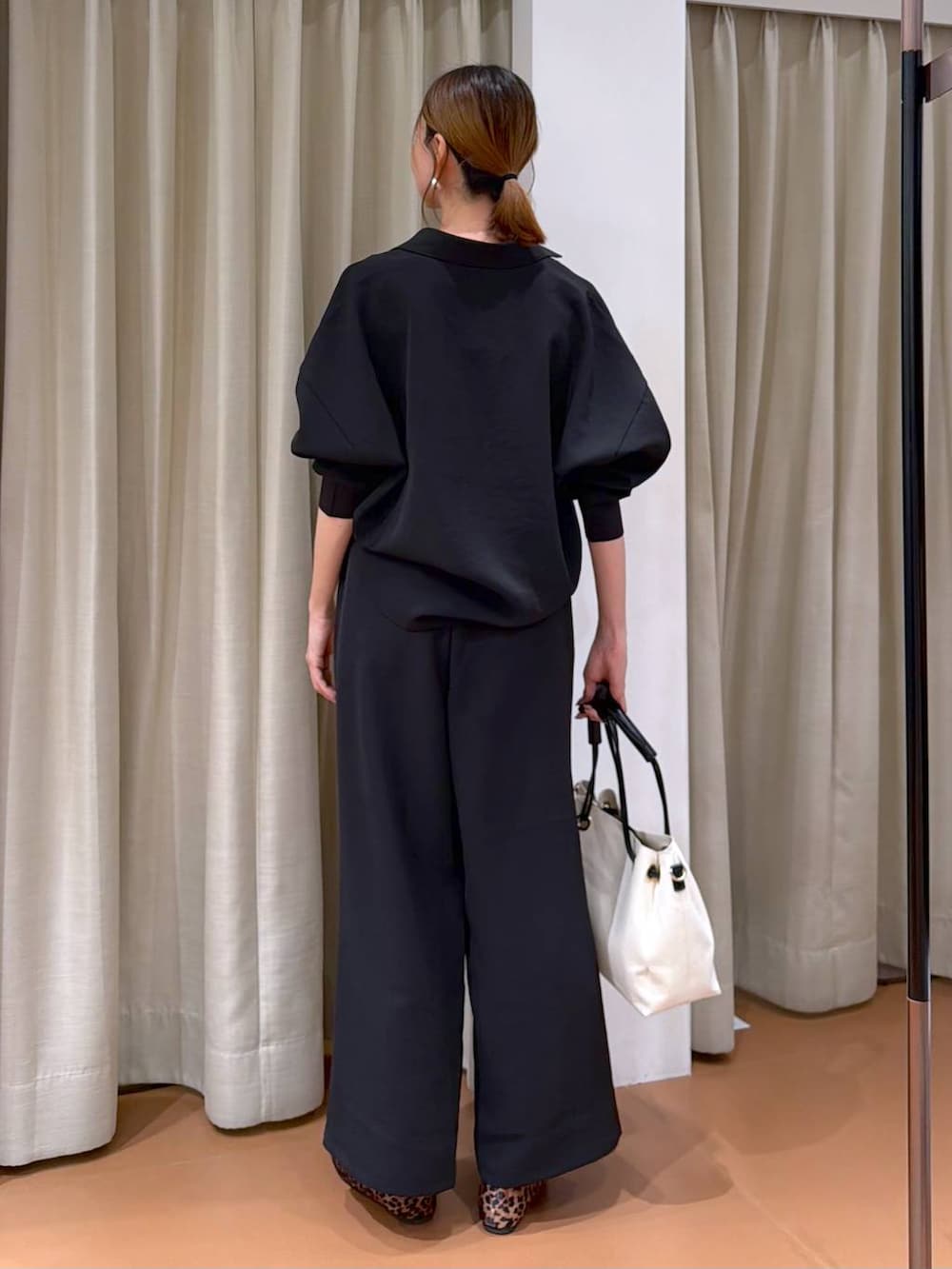 ブラウン系のパンプス、ホワイト系のトートバッグ、ブラック系のその他パンツを着用したレディースの冬コーディネートの4枚目の写真