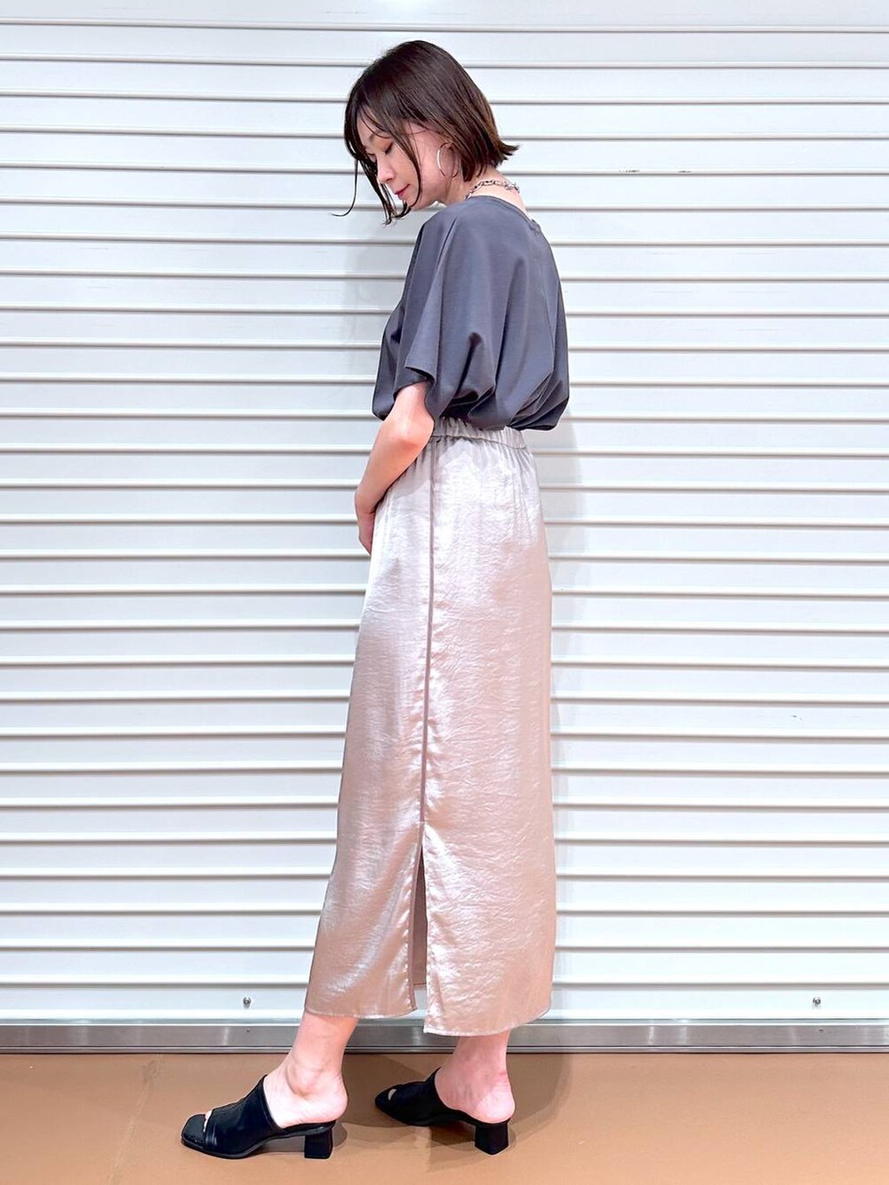 ベージュ系のスカート、ブラック系のサンダル、グレー系のTシャツ/カットソーを着用したレディースの春コーディネートの3枚目の写真