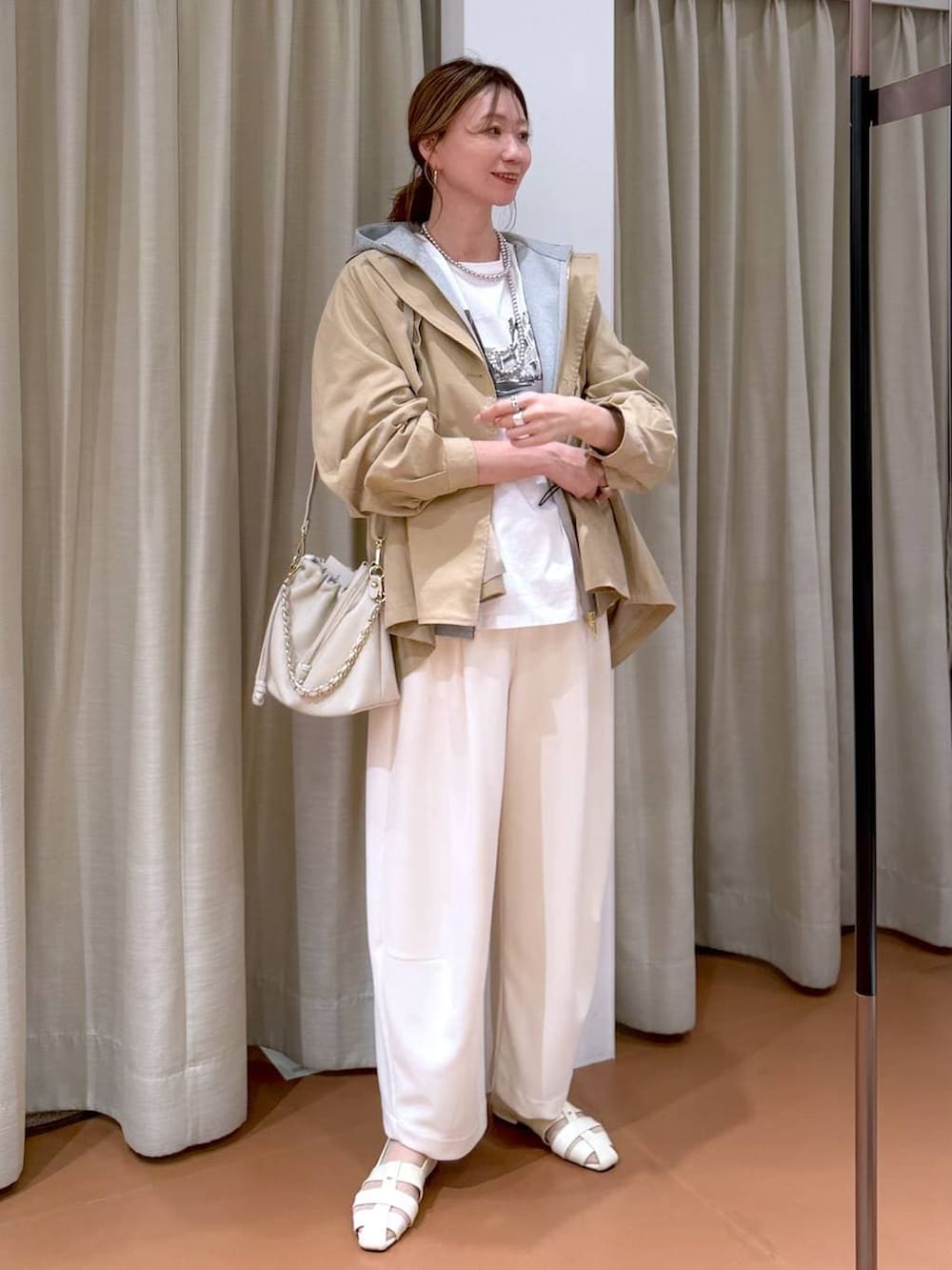 ホワイト系のハンドバッグ、グレー系のパーカー、ホワイト系のその他パンツを着用したレディースの春コーディネートの2枚目の写真