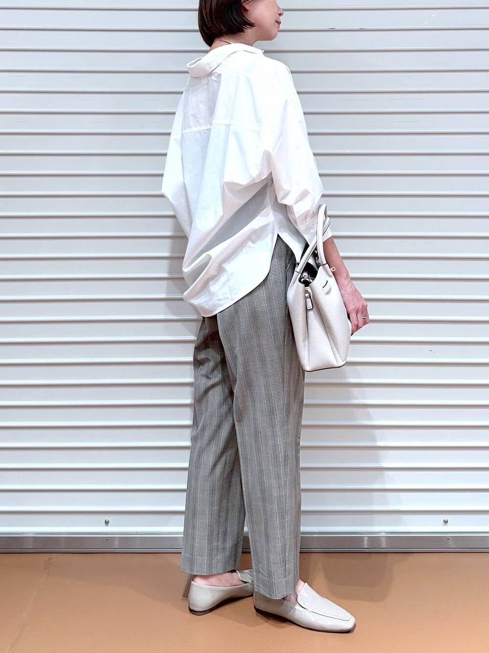 ブラウン系のその他パンツ、グレー系のハンドバッグ、ホワイト系のシャツ/ブラウスを着用したレディースの秋コーディネートの6枚目の写真