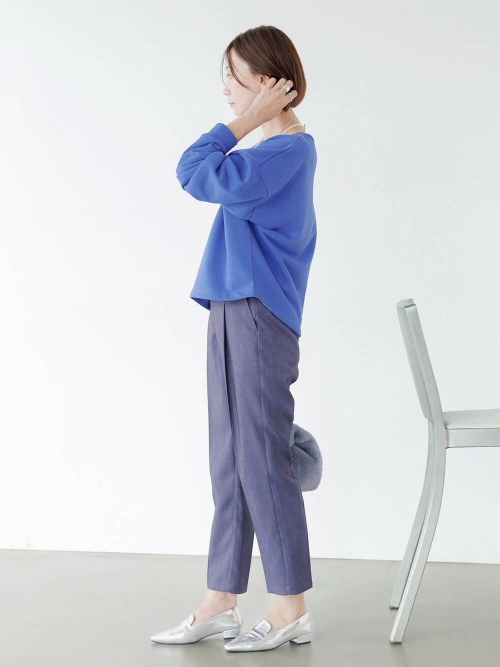 シルバー系のローファー、ブルー系のデニムパンツを着用したレディースの秋コーディネートの5枚目の写真