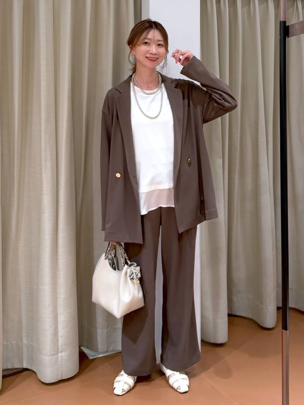 ブラウン系のその他パンツ、ホワイト系のパンプス、ホワイト系のTシャツ/カットソーを着用したレディースの春コーディネートの2枚目の写真