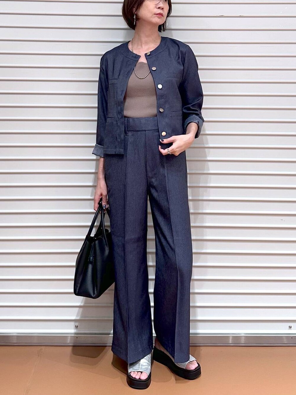 ブラック系のハンドバッグ、シルバー系のサンダル、ブラウン系のタンクトップを着用したレディースの夏コーディネートの5枚目の写真