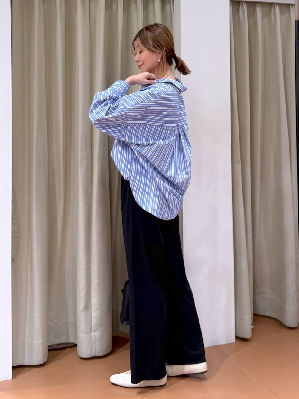 ブラック系のその他パンツ、ホワイト系のパンプス、ブラック系のハンドバッグを着用したレディースの冬コーディネートの3枚目の写真