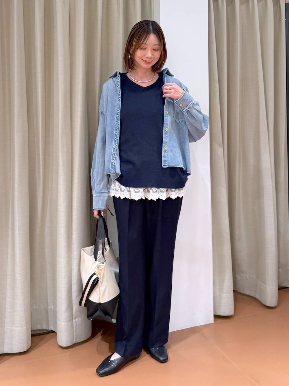 ベージュ系のトートバッグ、ブラック系のパンプス、ホワイト系のタンクトップを着用したレディースの冬コーディネートの2枚目の写真