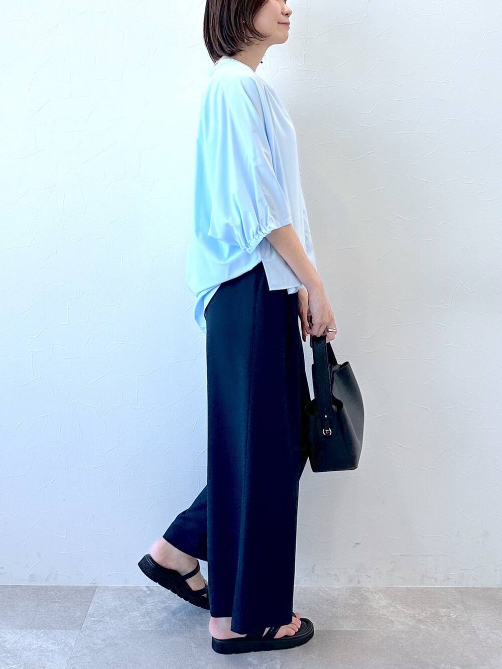 ブラック系のサンダル、ブルー系のシャツ/ブラウス、ブラック系のハンドバッグを着用したレディースの夏コーディネートの6枚目の写真