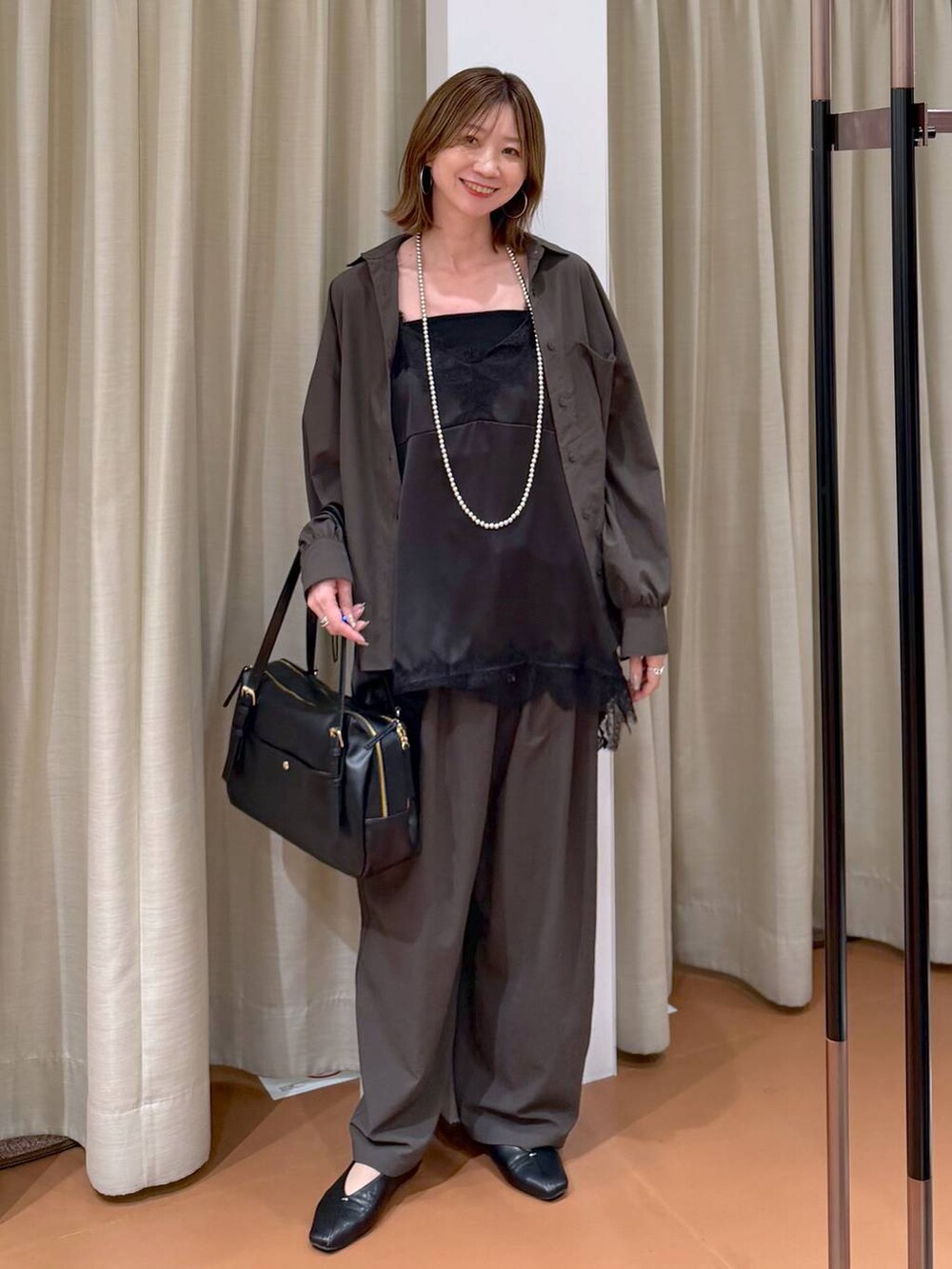 ブラック系のパンプス、ブラック系のキャミソール、ブラック系のボストンバッグを着用したレディースの春コーディネートの2枚目の写真