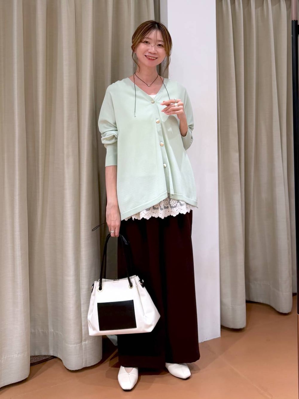 ホワイト系のパンプス、ホワイト系のタンクトップ、ホワイト系のトートバッグを着用したレディースの春コーディネートの6枚目の写真