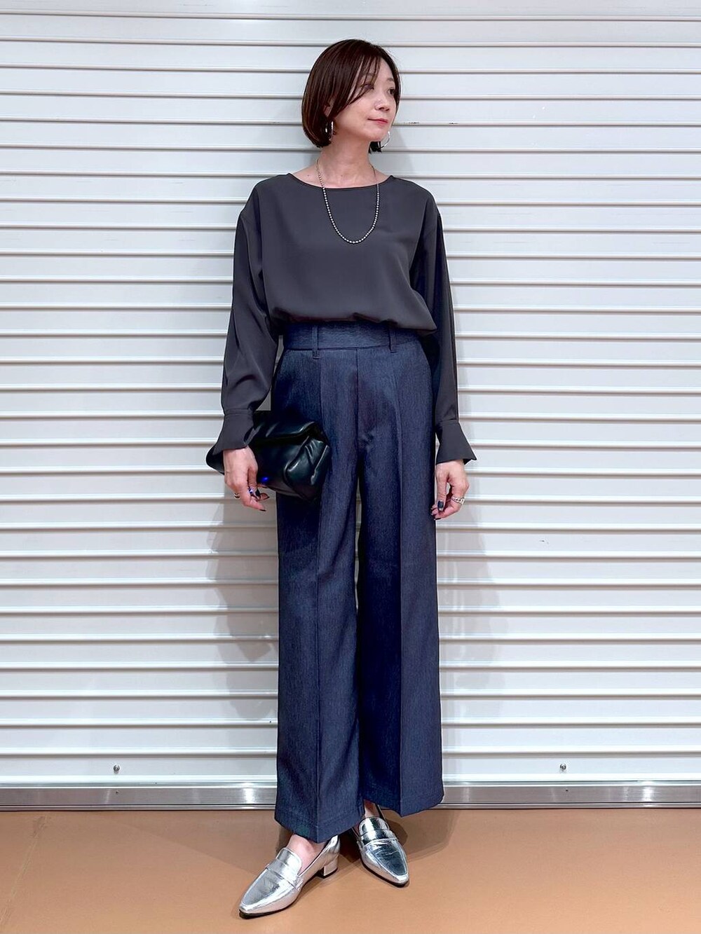シルバー系のローファー、ブルー系のデニムパンツ、グレー系のTシャツ/カットソーを着用したレディースの秋コーディネートの2枚目の写真