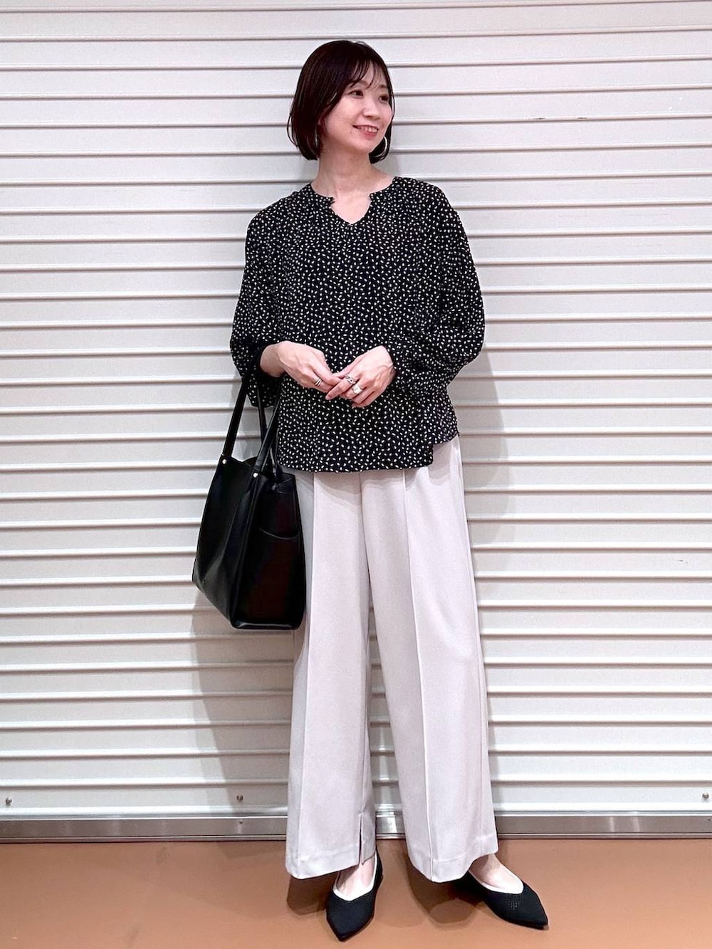 ブラック系のパンプス、ブラック系のトートバッグ、ベージュ系のその他パンツを着用したレディースの春コーディネートの2枚目の写真