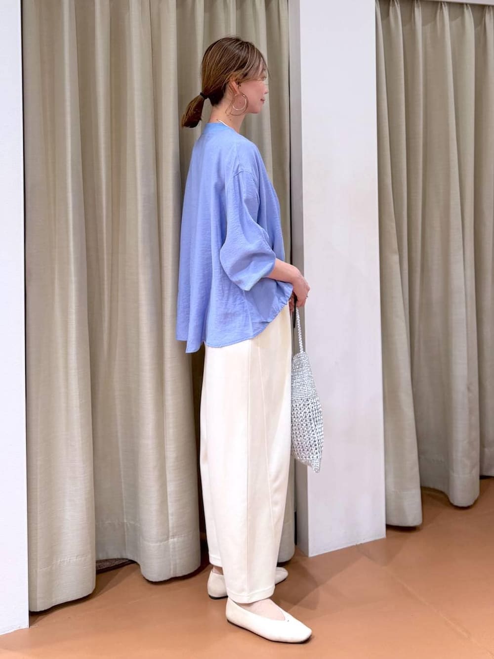 ホワイト系のTシャツ/カットソー、ホワイト系のパンプス、ブルー系のカーディガン/ボレロを着用したレディースの春コーディネートの5枚目の写真