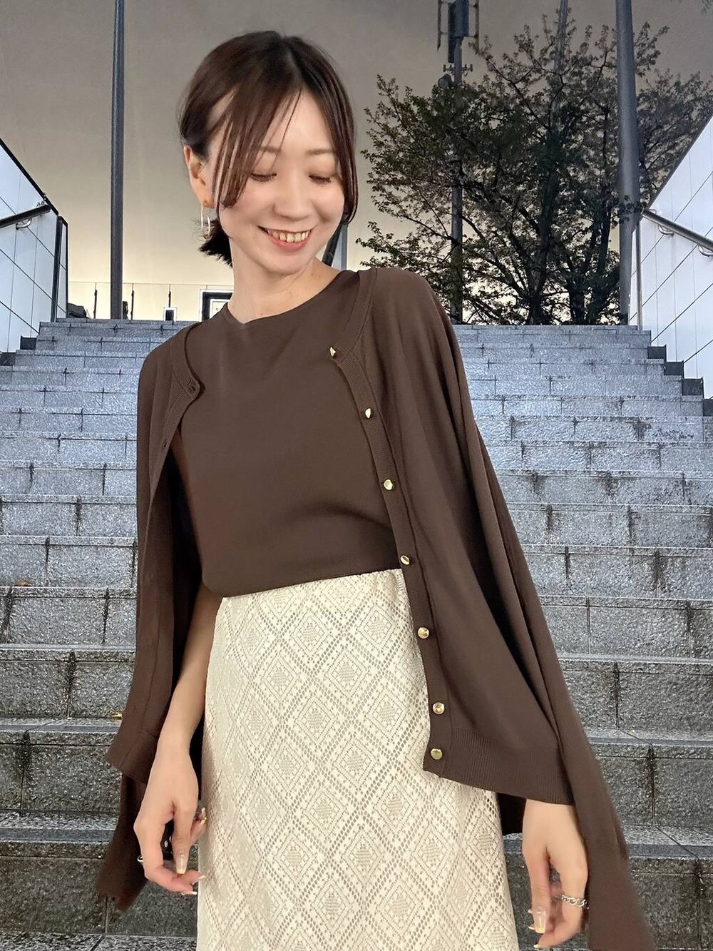 ブラウン系のカーディガン/ボレロ、ブラウン系のニット/セーター、ホワイト系のパンプスを着用したレディースの春コーディネートの4枚目の写真