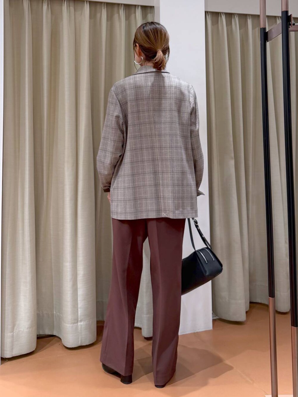 ブラック系のブーツ、ブラック系のテーラードジャケット、ブラック系のショルダーバッグを着用したレディースの冬コーディネートの4枚目の写真