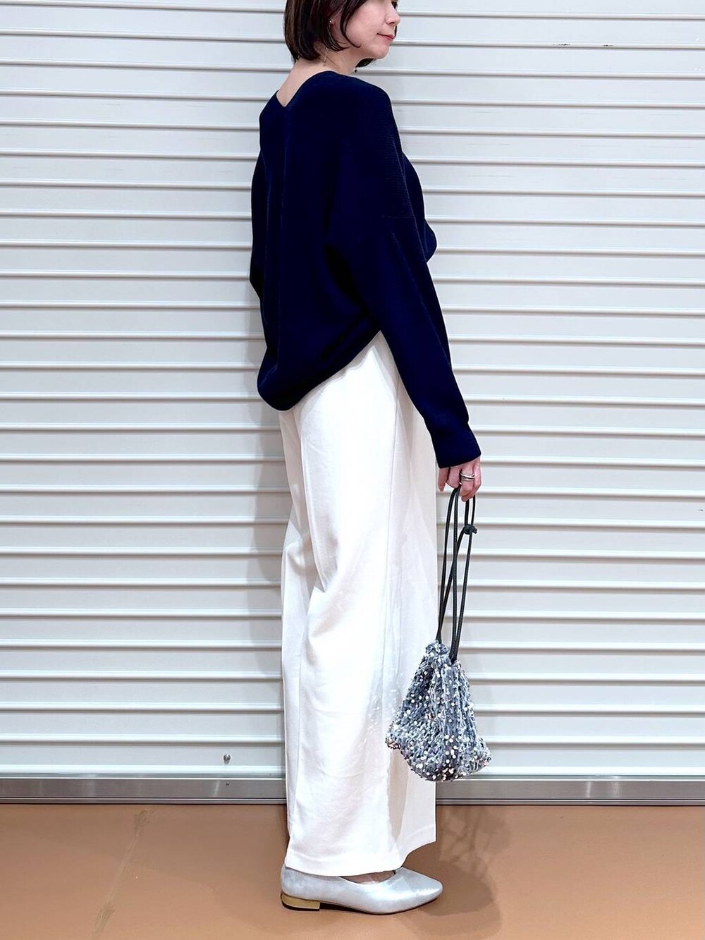 ブルー系のニット/セーター、シルバー系のパンプスを着用したレディースの春コーディネートの6枚目の写真