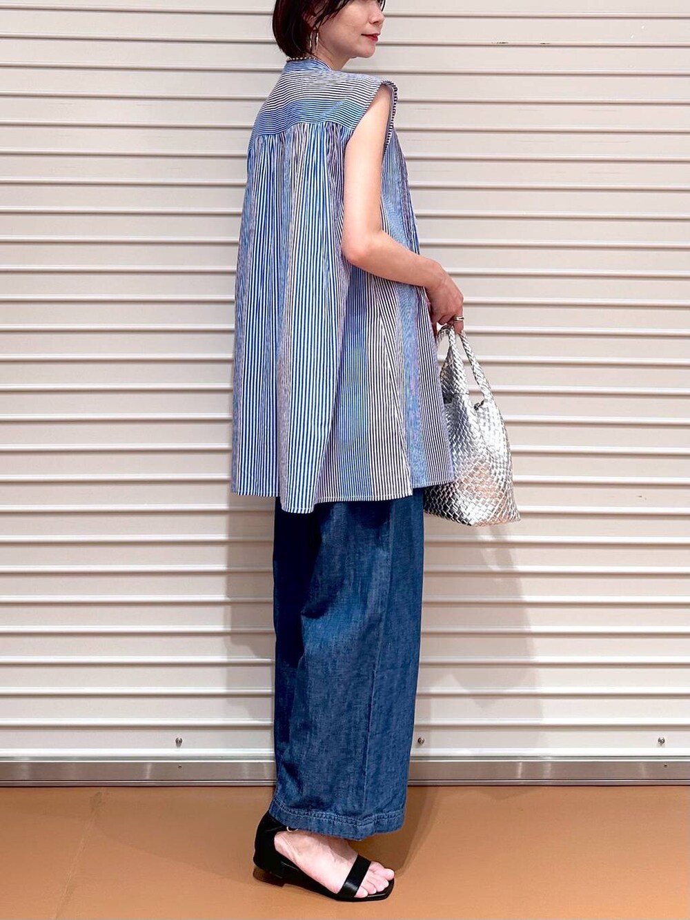 ブルー系のデニムパンツ、ブルー系のデニムパンツ、シルバー系のトートバッグを着用したレディースの夏コーディネートの6枚目の写真