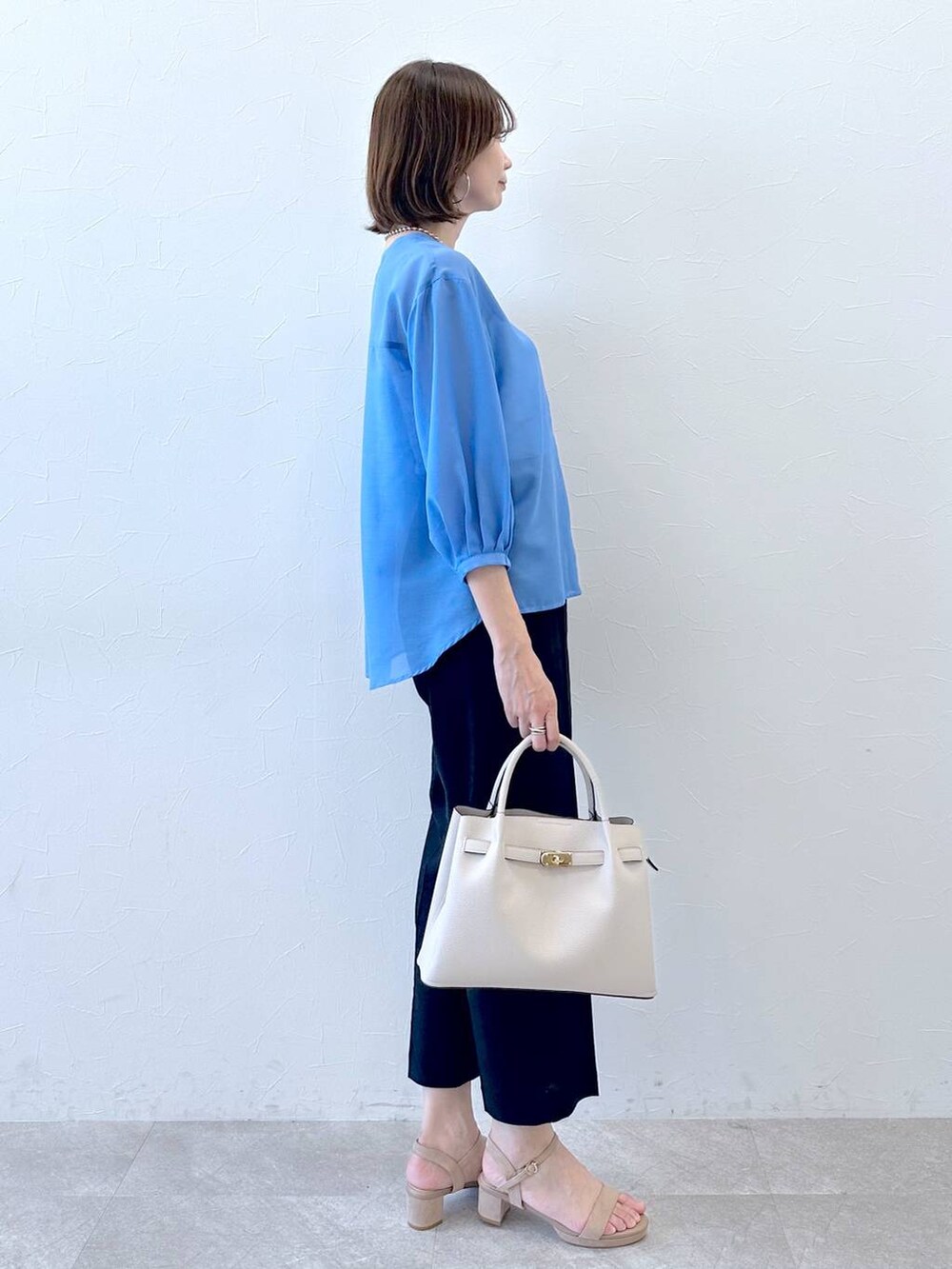 ブルー系のその他パンツ、ベージュ系のサンダル、ブルー系のシャツ/ブラウスを着用したレディースの秋コーディネートの3枚目の写真