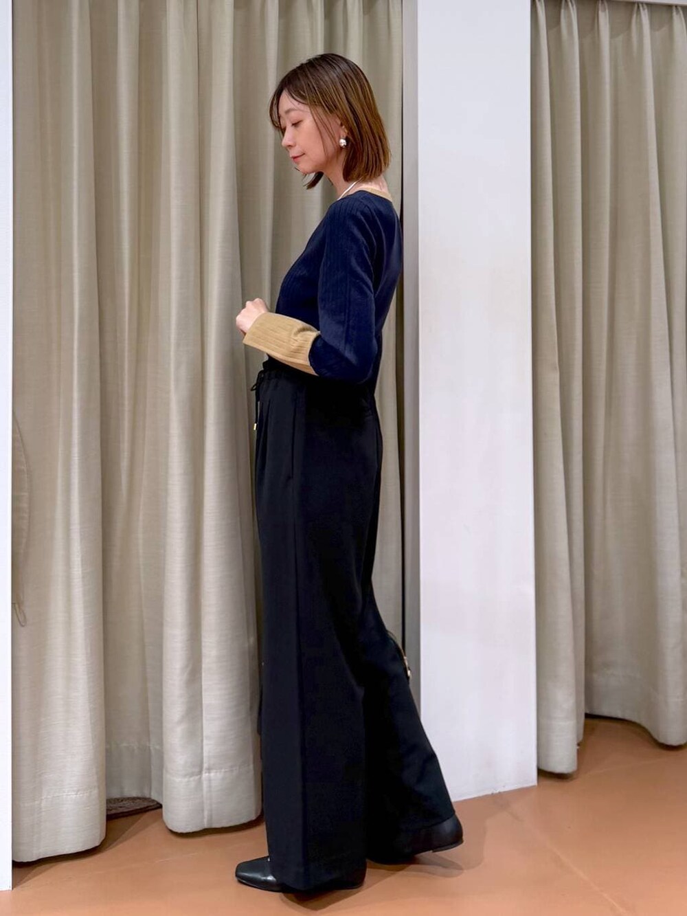 ブラック系のその他パンツ、ブラック系のパンプス、ブルー系のニット/セーターを着用したレディースの冬コーディネートの5枚目の写真