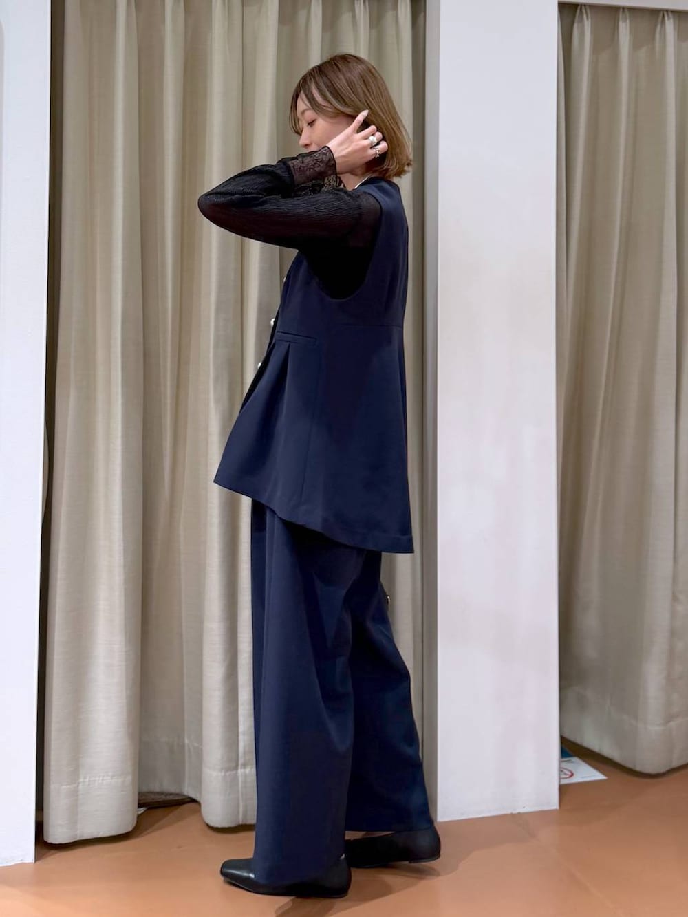 ブラック系のハンドバッグ、ブラック系のパンプス、ブラック系のTシャツ/カットソーを着用したレディースの冬コーディネートの3枚目の写真