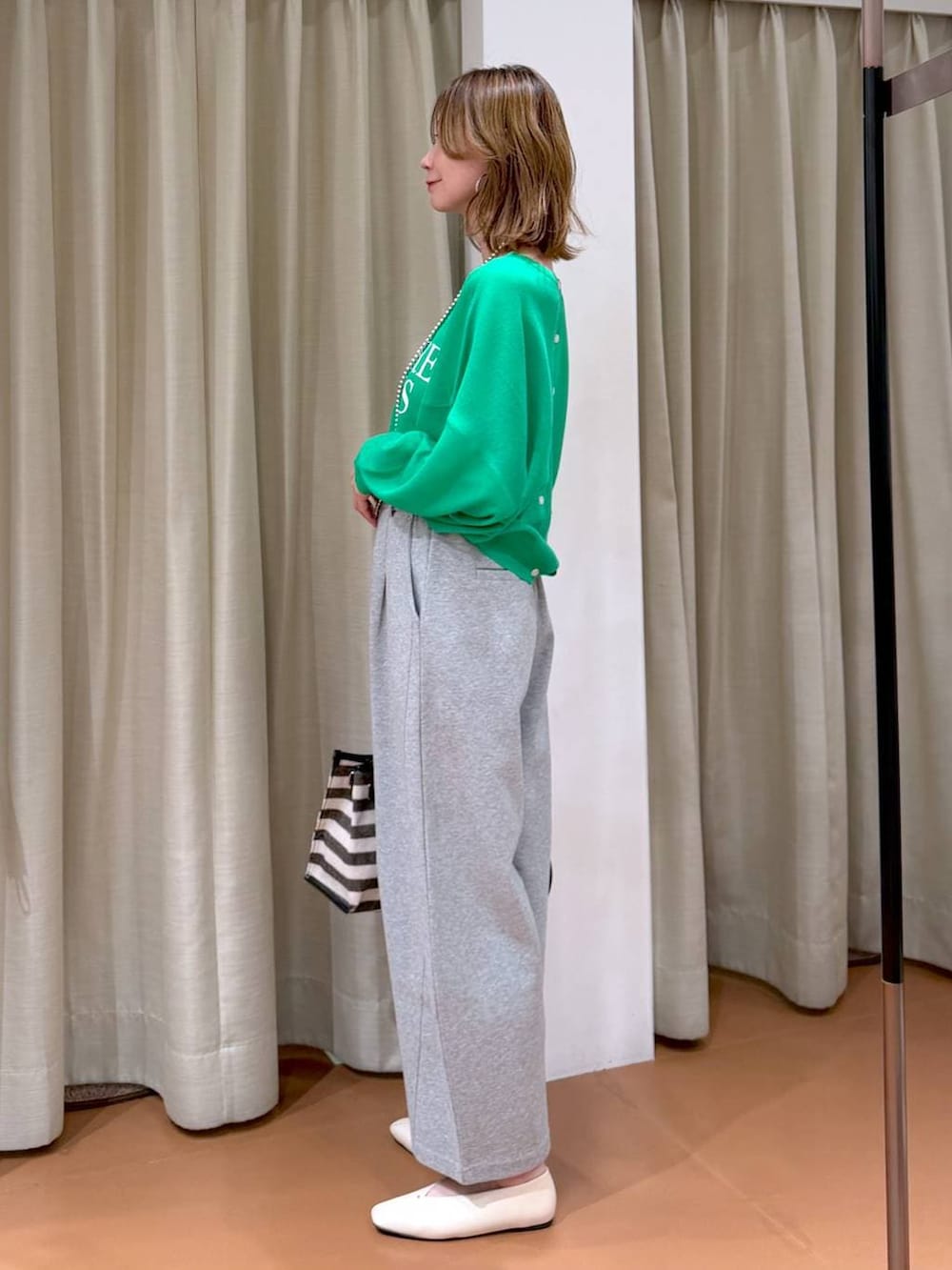 ホワイト系のパンプス、グレー系のスウェットパンツ、ブラック系のトートバッグを着用したレディースの春コーディネートの3枚目の写真