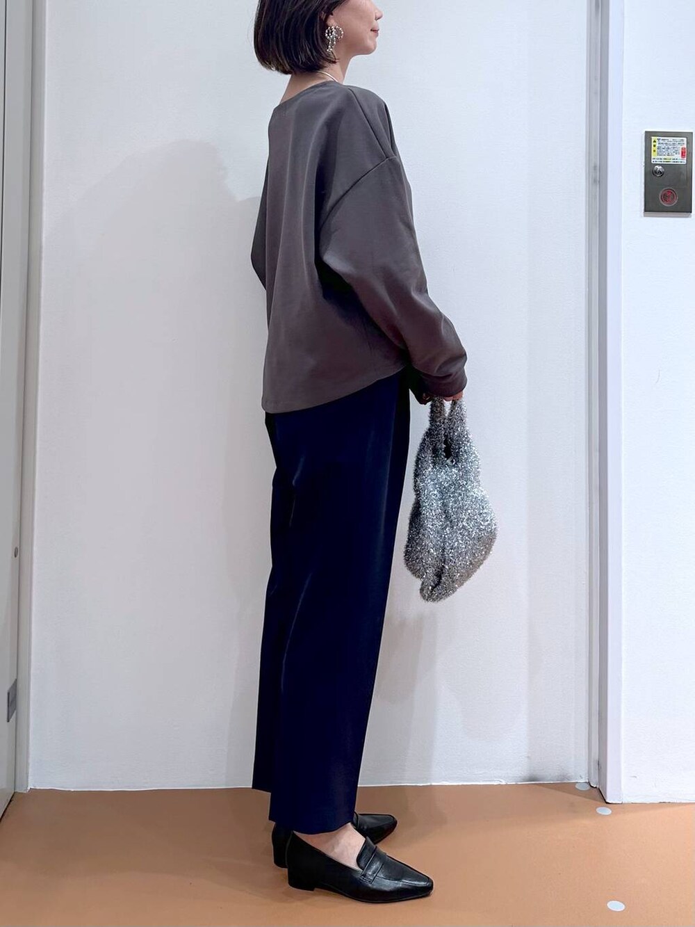 ブルー系のその他パンツ、ブラック系のローファー、シルバー系のハンドバッグを着用したレディースの秋コーディネートの6枚目の写真