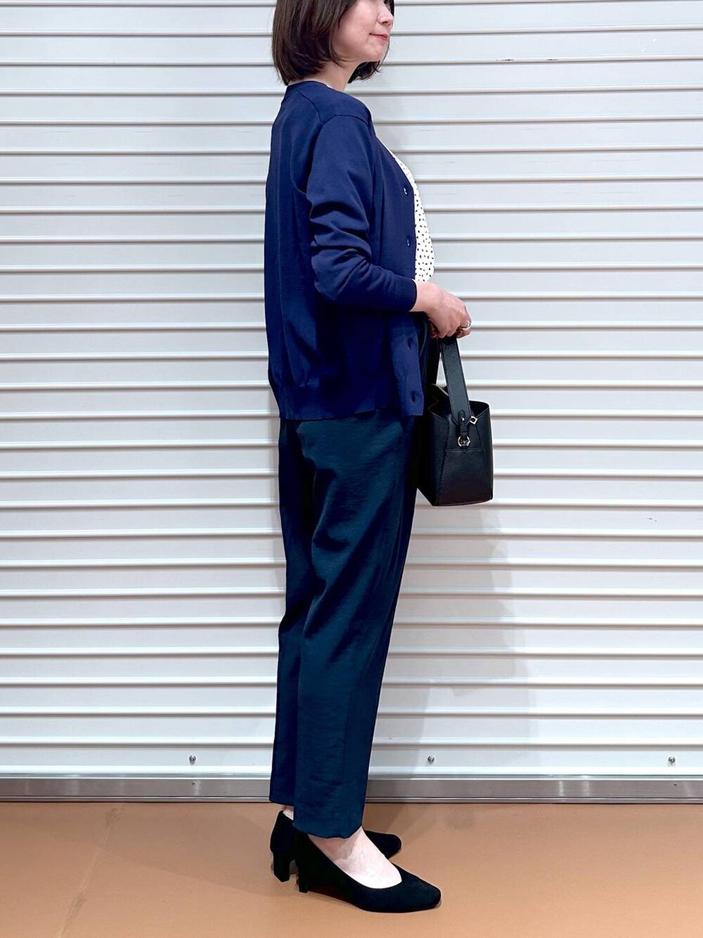 ホワイト系のシャツ/ブラウス、ブルー系のカーディガン/ボレロ、ブラック系のハンドバッグを着用したレディースの夏コーディネートの3枚目の写真