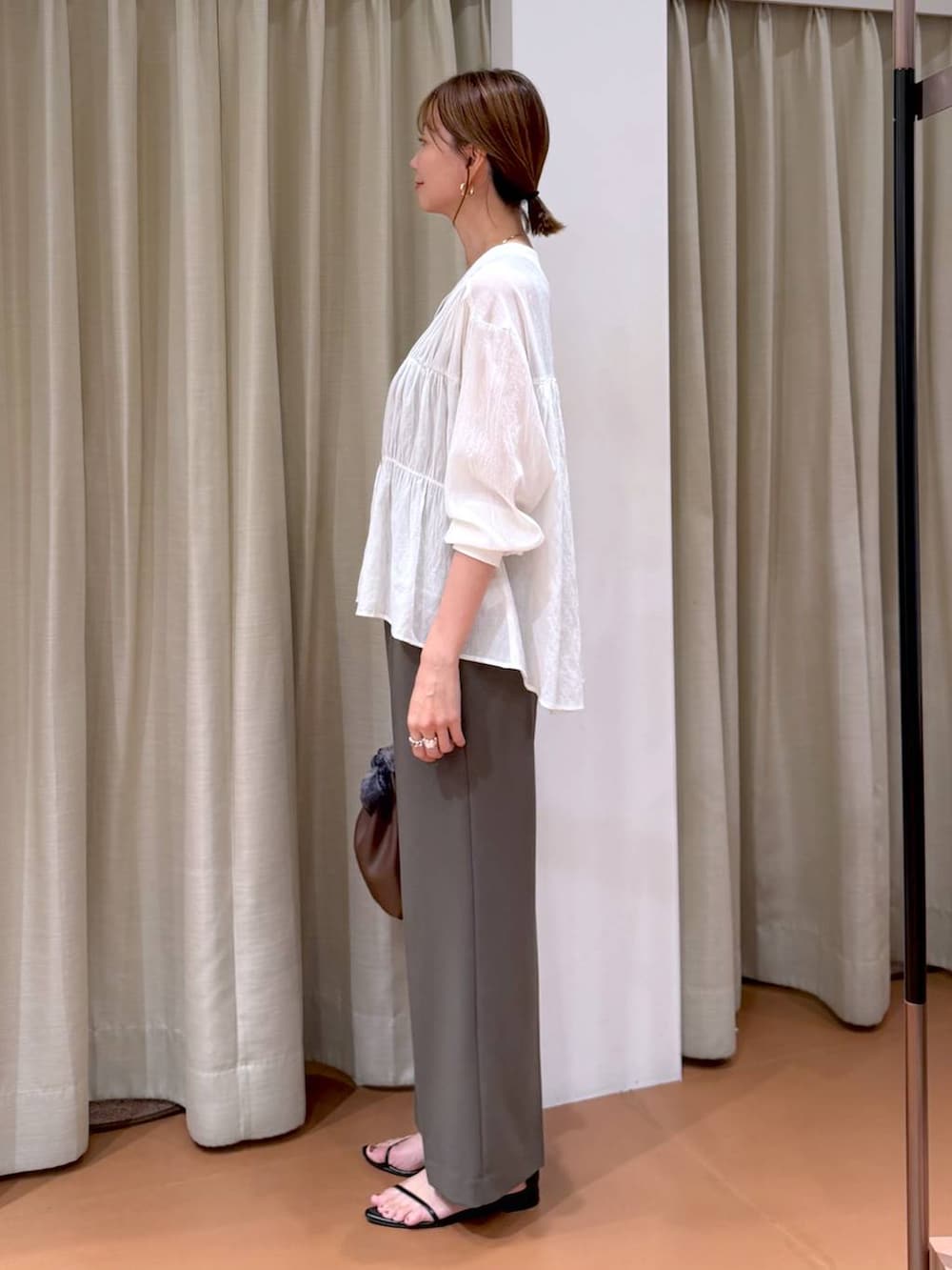 グリーン系のその他パンツ、ホワイト系のシャツ/ブラウス、ブラウン系のタンクトップを着用したレディースの秋コーディネートの3枚目の写真