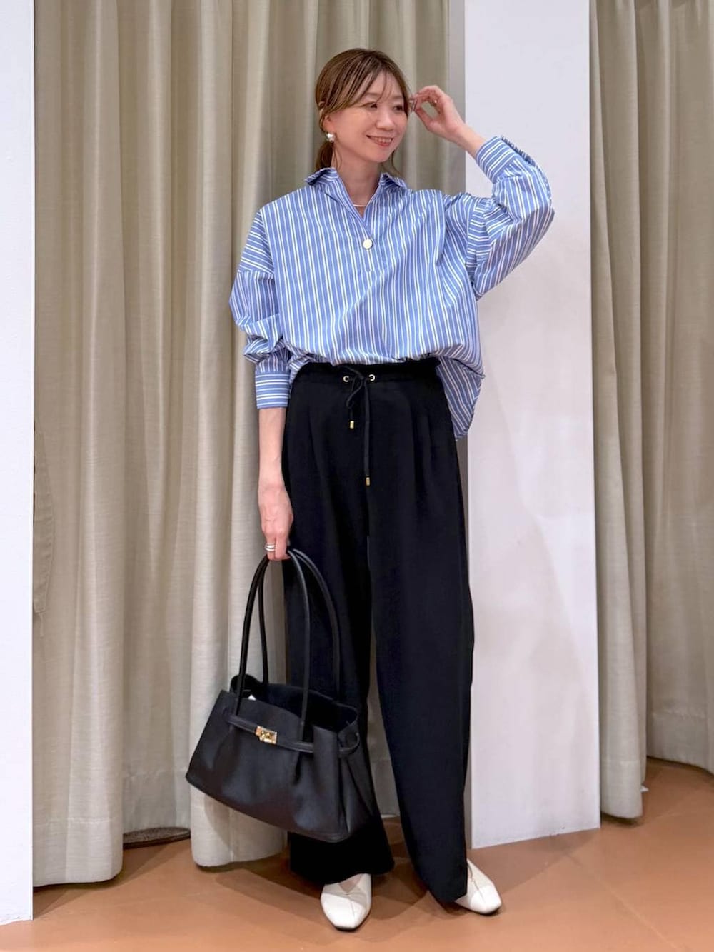 ブラック系のその他パンツ、ホワイト系のパンプス、ブラック系のハンドバッグを着用したレディースの冬コーディネートの2枚目の写真