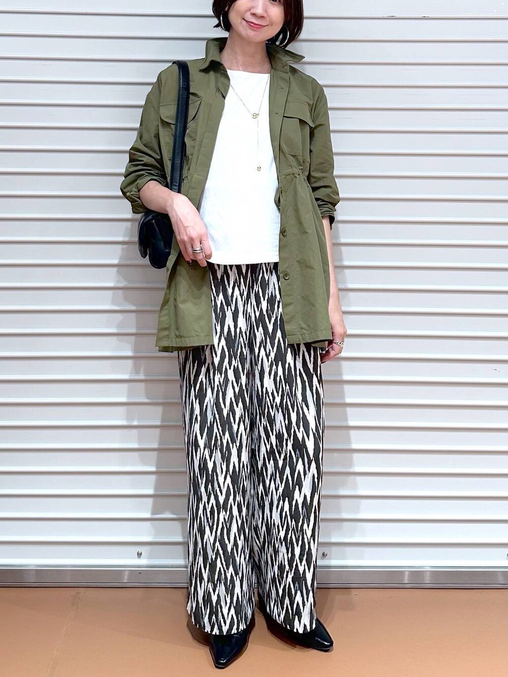 ブラック系のローファー、ホワイト系のTシャツ/カットソー、グリーン系のその他アウターを着用したレディースの秋コーディネートの5枚目の写真