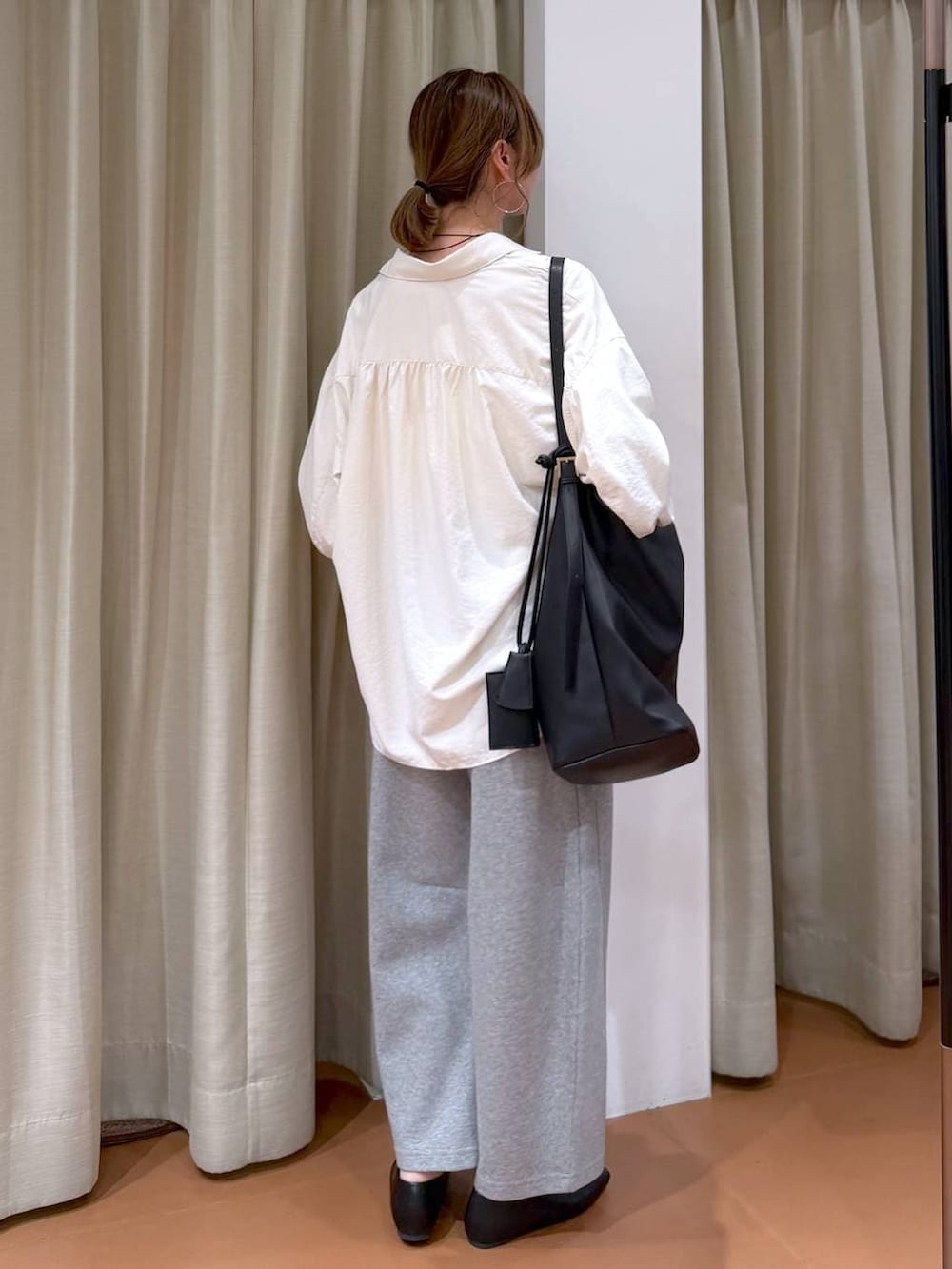 ブラック系のパンプス、グレー系のスウェットパンツ、ブラック系のトートバッグを着用したレディースの春コーディネートの4枚目の写真