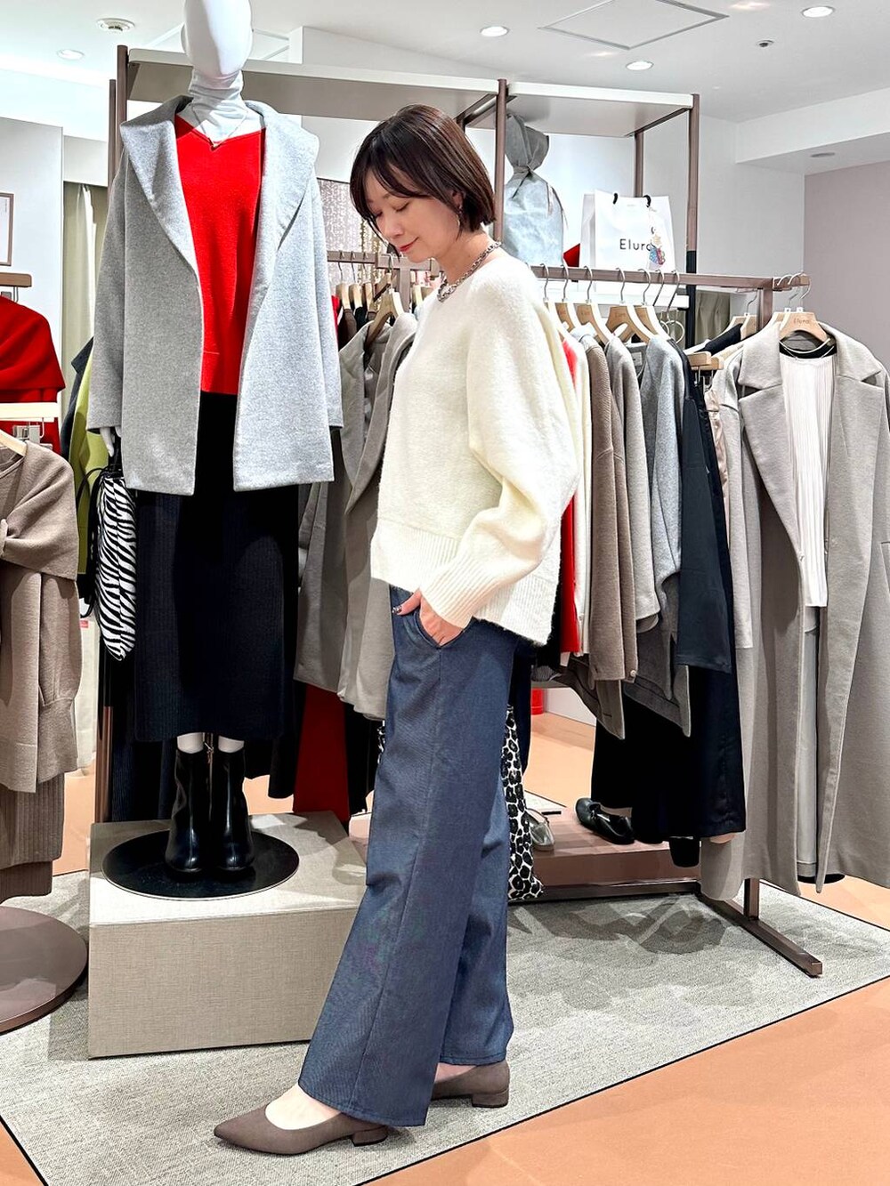ブルー系のデニムパンツ、ホワイト系のニット/セーター、ブラウン系のパンプスを着用したレディースの冬コーディネートの3枚目の写真