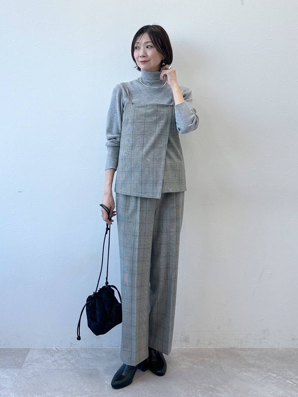 ブラック系のブーツ、グレー系のニット/セーターを着用したレディースの冬コーディネートの2枚目の写真