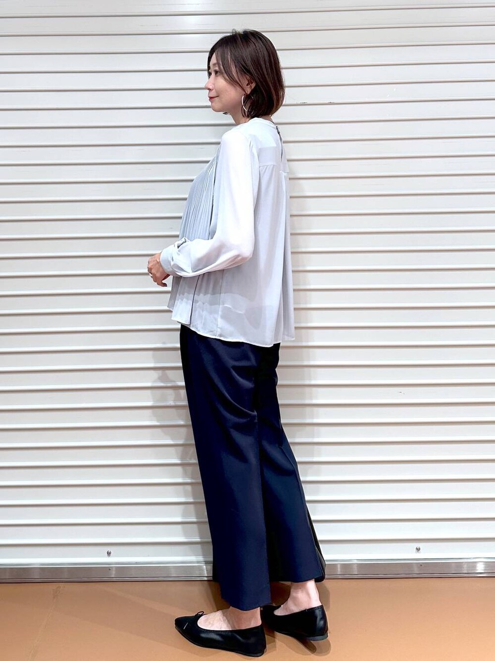 ブルー系のその他パンツ、ブラック系のトートバッグ、ブラック系のパンプスを着用したレディースの秋コーディネートの3枚目の写真