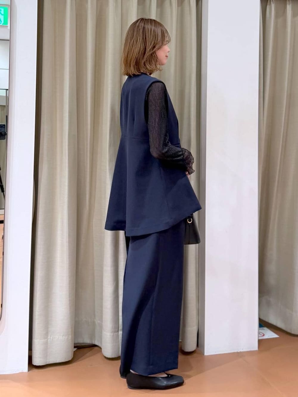 ブラック系のハンドバッグ、ブラック系のパンプス、ブラック系のTシャツ/カットソーを着用したレディースの冬コーディネートの5枚目の写真