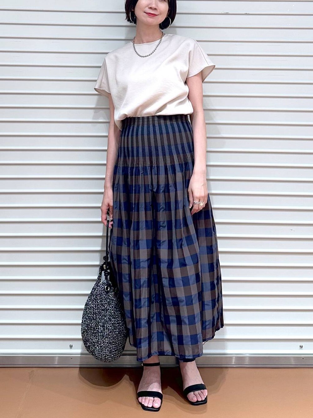 ベージュ系のシャツ/ブラウス、ブラウン系のスカート、ブラック系のサンダルを着用したレディースの夏コーディネートの5枚目の写真