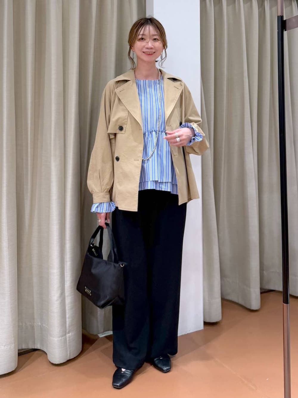 ブラック系のその他パンツ、ブラック系のパンプス、ブルー系のシャツ/ブラウスを着用したレディースの春コーディネートの6枚目の写真