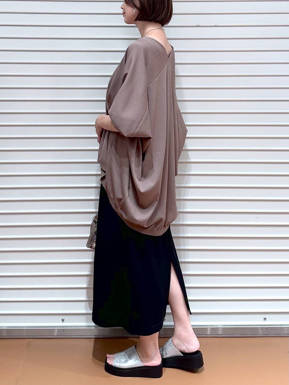 ブラック系のスカート、ブラウン系のカーディガン/ボレロ、シルバー系のサンダルを着用したレディースの夏コーディネートの6枚目の写真