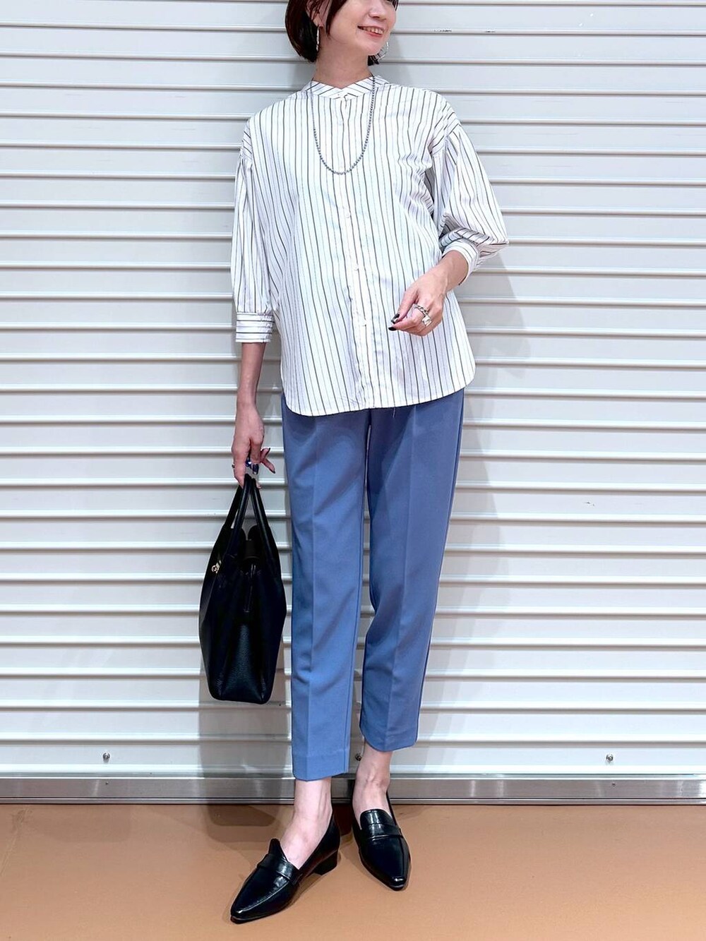 ブルー系のその他パンツ、ブラック系のハンドバッグ、ブラック系のローファーを着用したレディースの秋コーディネートの5枚目の写真